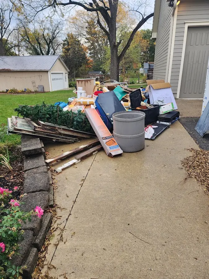 Dumpster being loaded with debris for Estate Cleanout Dumpster Rental in Winterport